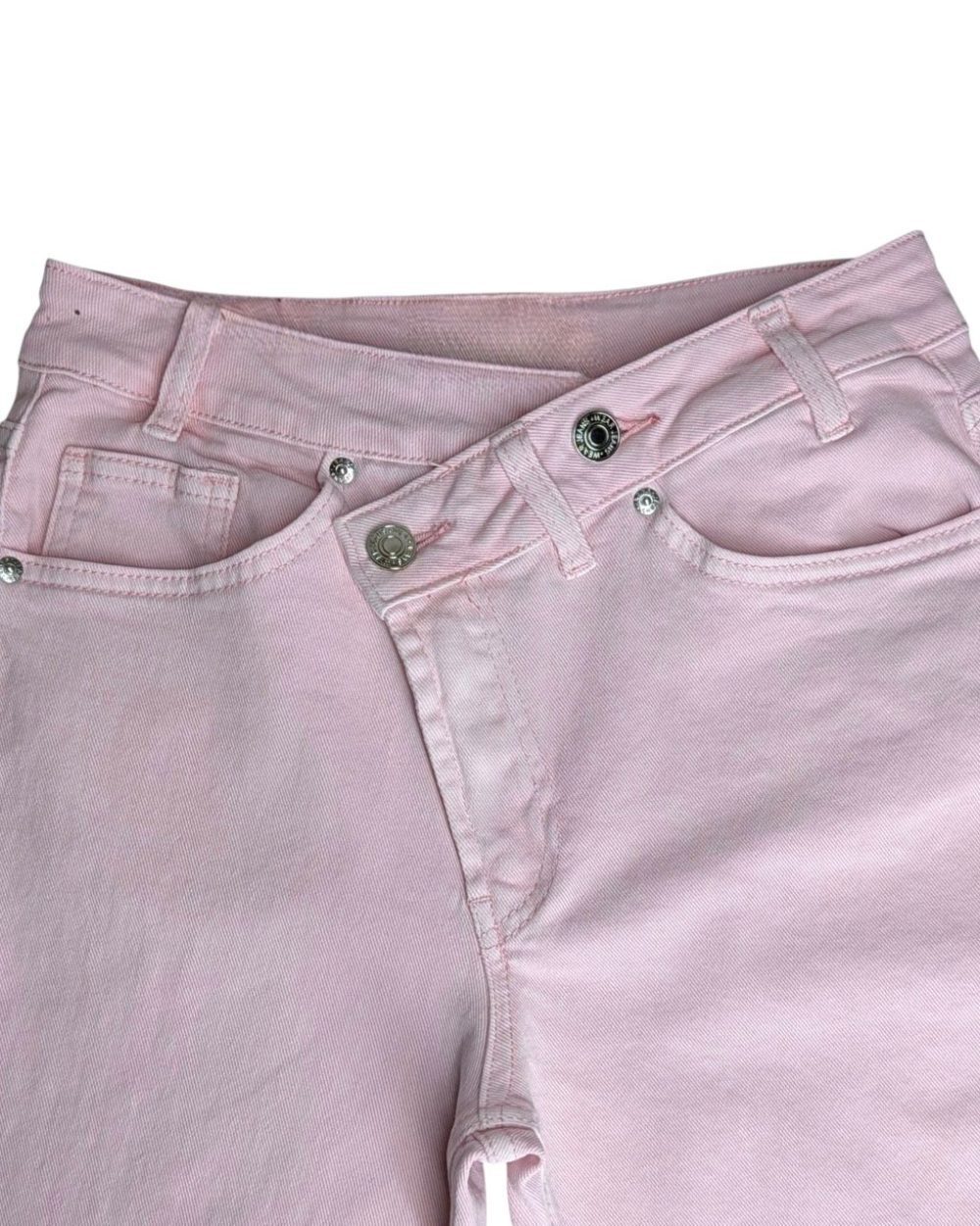 Calça ganga rosa wide leg com cintura média cruzada. Moderna, confortável e fácil de combinar no dia a dia.