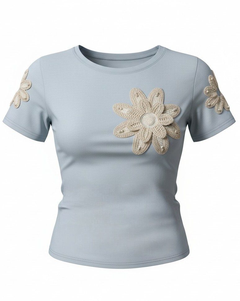 Modelo a usar a t-shirt azul com flor de croché, estilo casual.